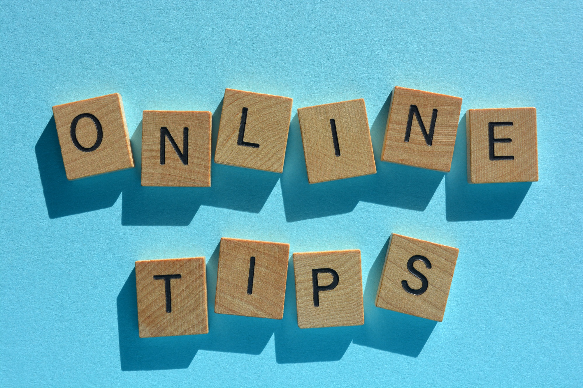 Online Tips, words in wooden alphabet letters isolated on blue background