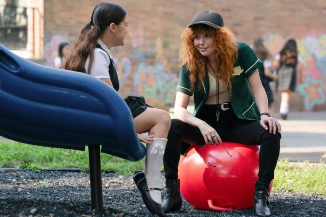 A child at the bottom of a slide where she speaks to an adult sitting on an exercise ball; Eva Jade Halford and Natasha Lyonne in 'Poker Face'