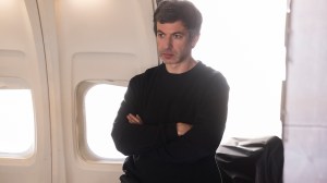 Nathan Fielder in 'The Rehearsal' Season 2, shown here with his arms folded, standing on the set of an airplane