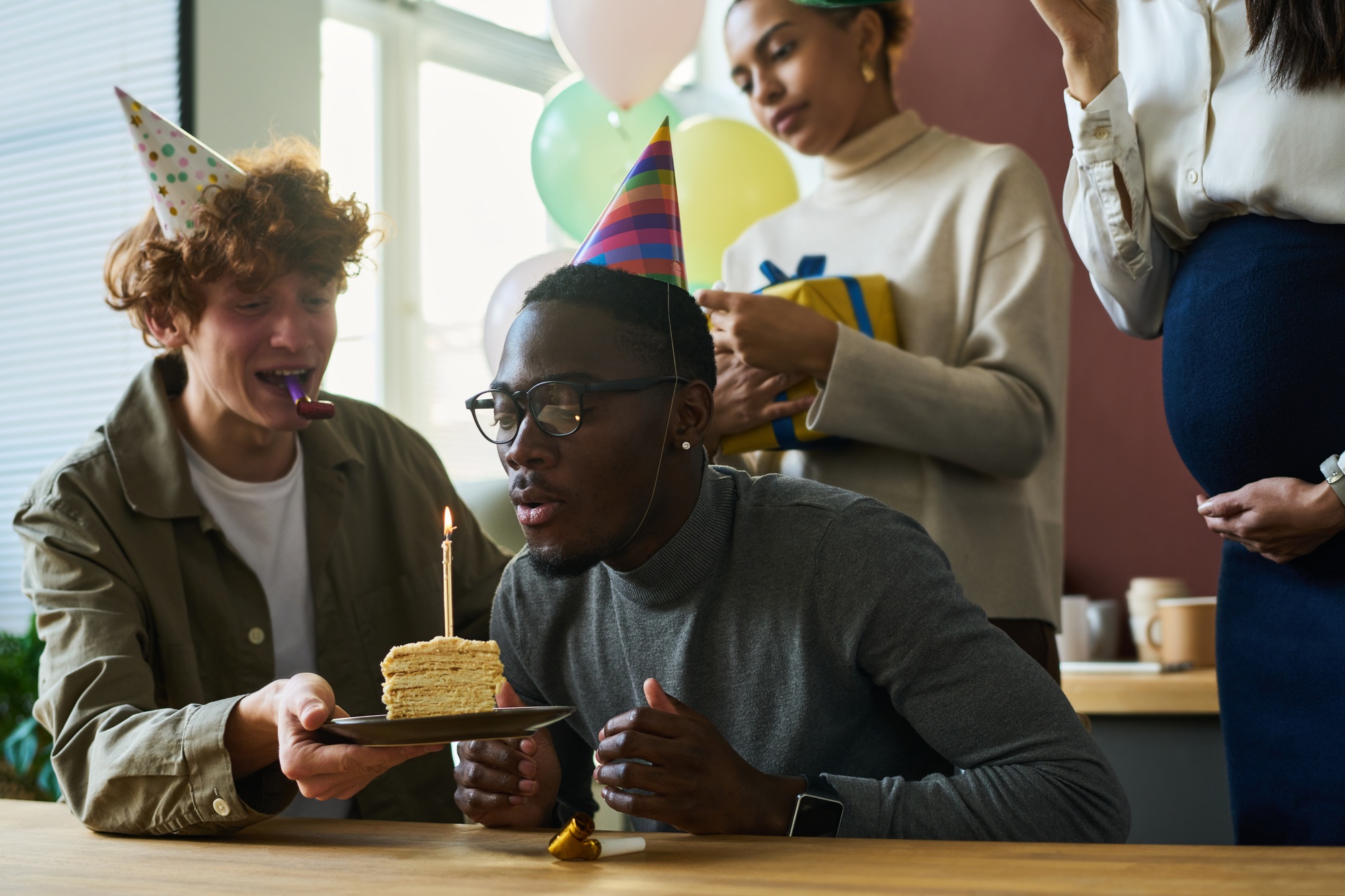 Blowing candle on piece of birthday cake