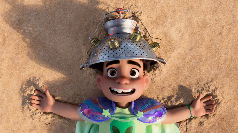 Yonas Kibreab as the voice of Elio wearing a homemade helmet and space outfit while laying on the beach in Elio