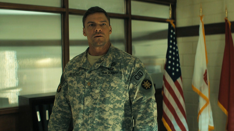 Alan Ritchson as Jack Reacher stands in his Army fatigues in his office in Reacher
