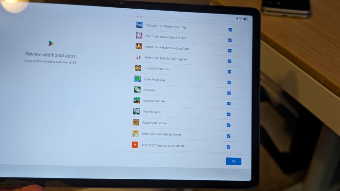 Screenshot of a Lenovo Android tablet displaying a list of additional apps available for download via Wi-Fi, including gaming and puzzle apps.