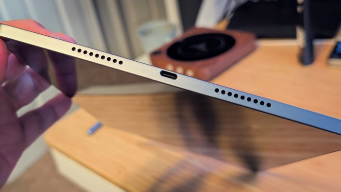 Close-up view of the edge of a Lenovo tablet showcasing the speaker holes and USB-C port.