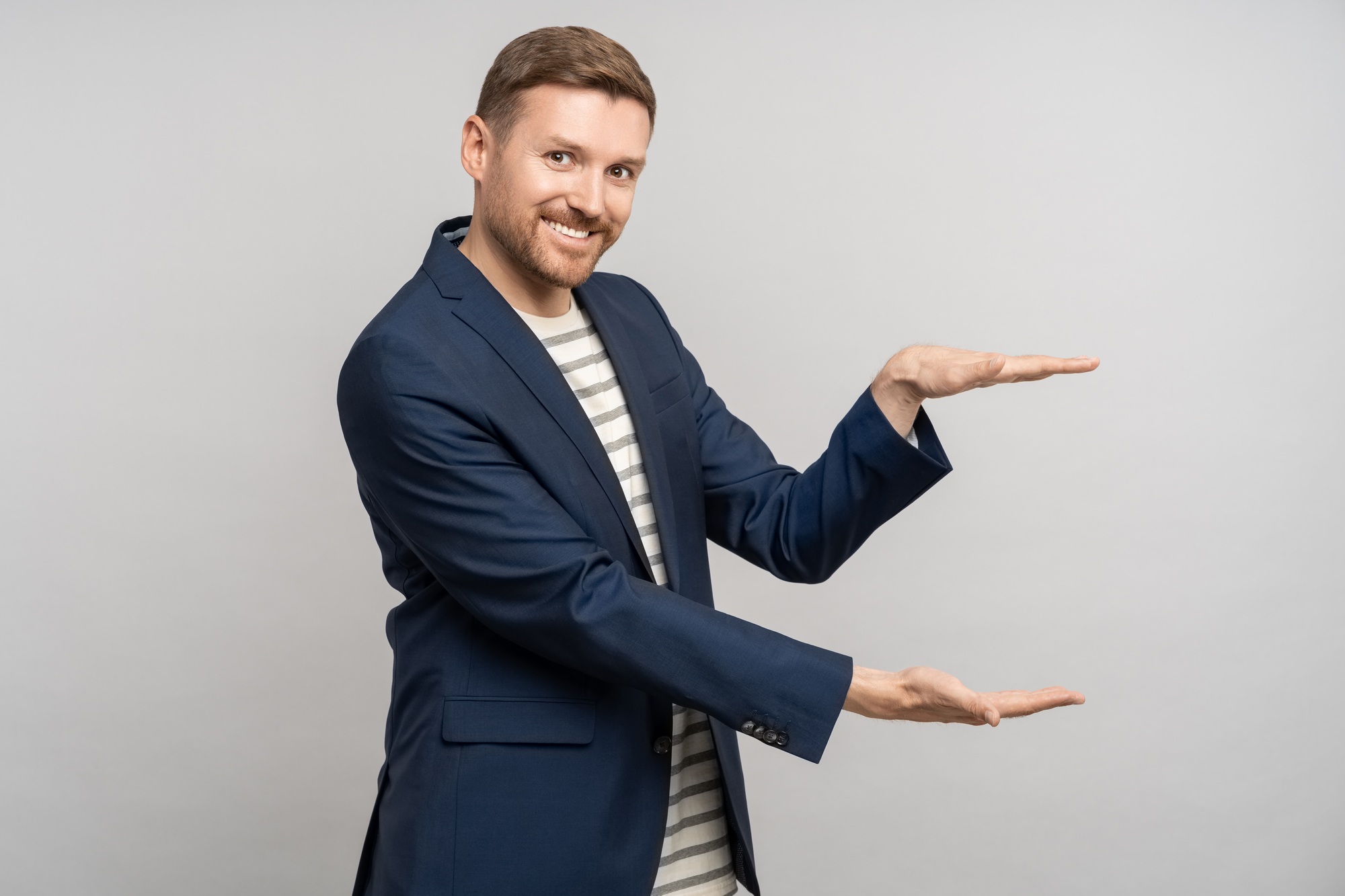 Interested man promoter in business suit shows with hands size of discount for sale on studio wall