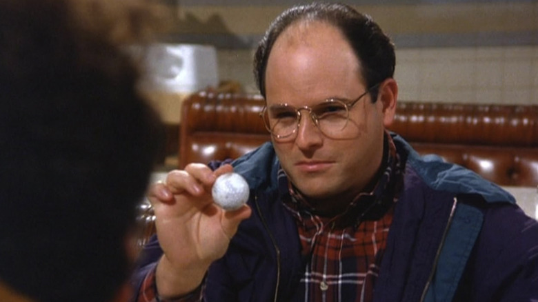 George holding a golf ball in an episode of Seinfeld