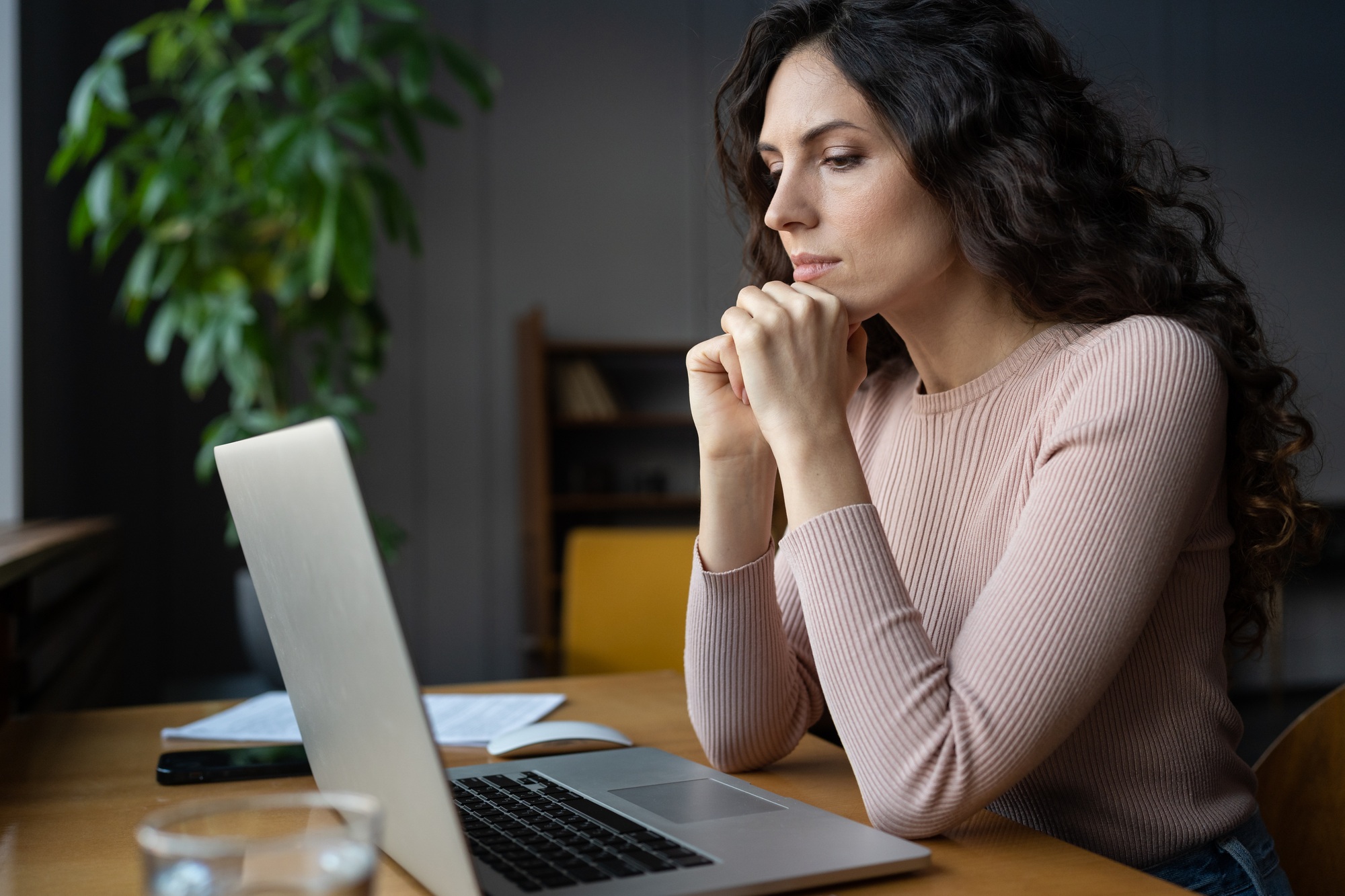 Thoughtful female look at laptop monitor serious develop business strategy or project plan pondering