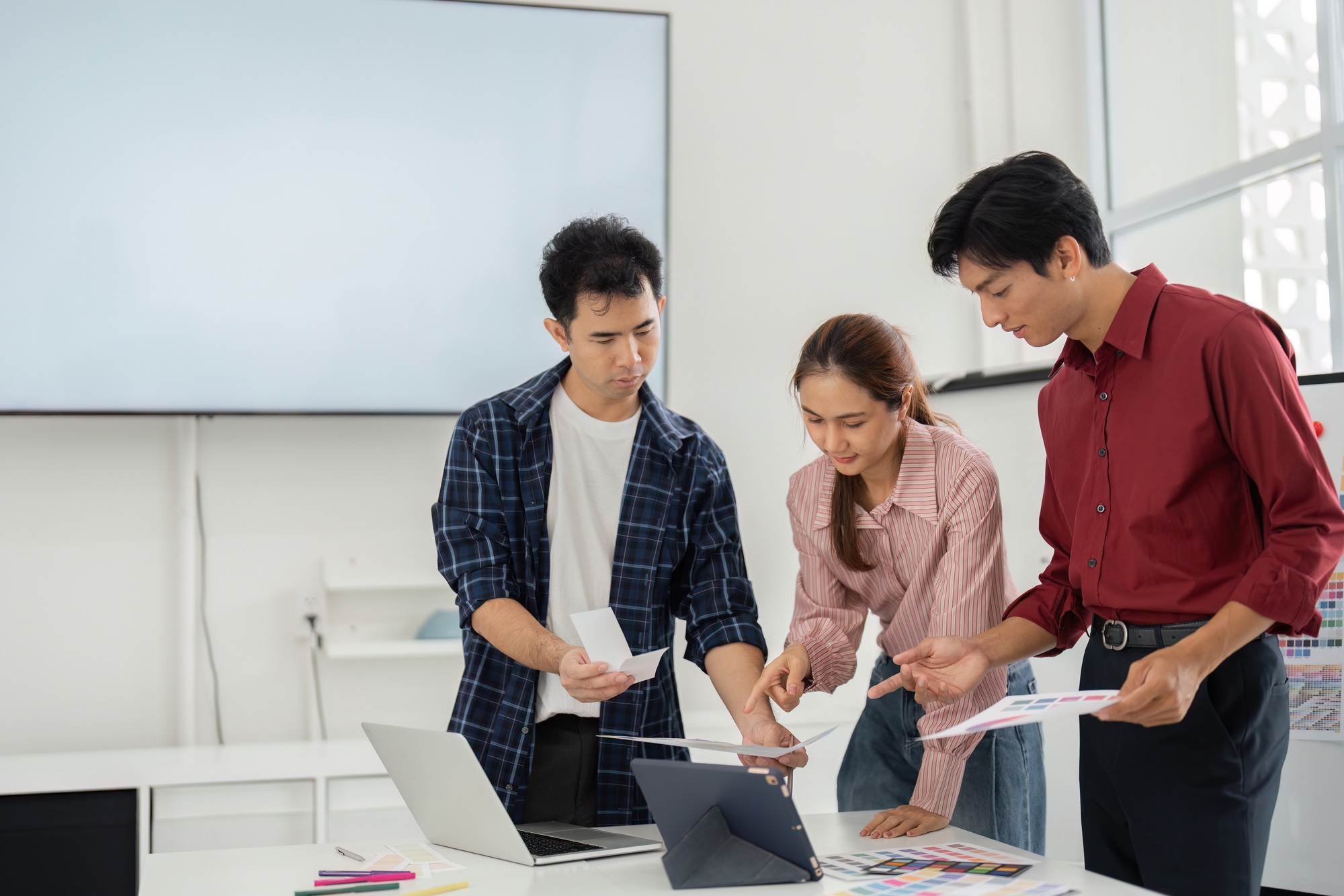 Three designers engaged in a lively discussion about color schemes and branding concepts.