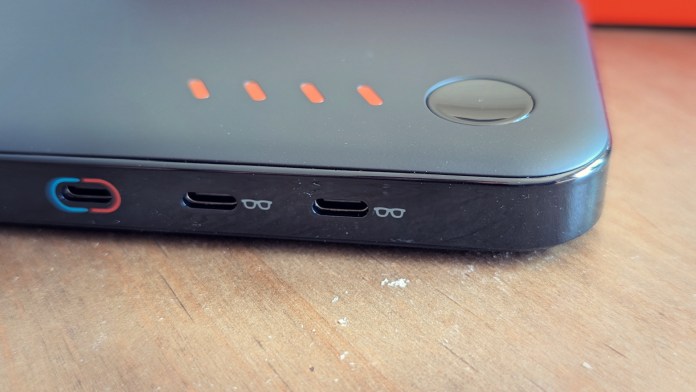Close-up view of the side of a device with multiple USB ports, including a blue and two black USB-C ports, along with indicator lights.