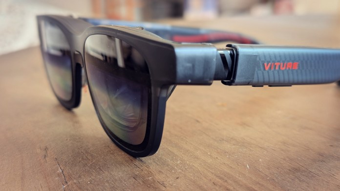 Close-up of VITURE Luma Pro XR glasses resting on a wooden surface, showcasing their sleek design and matte finish.