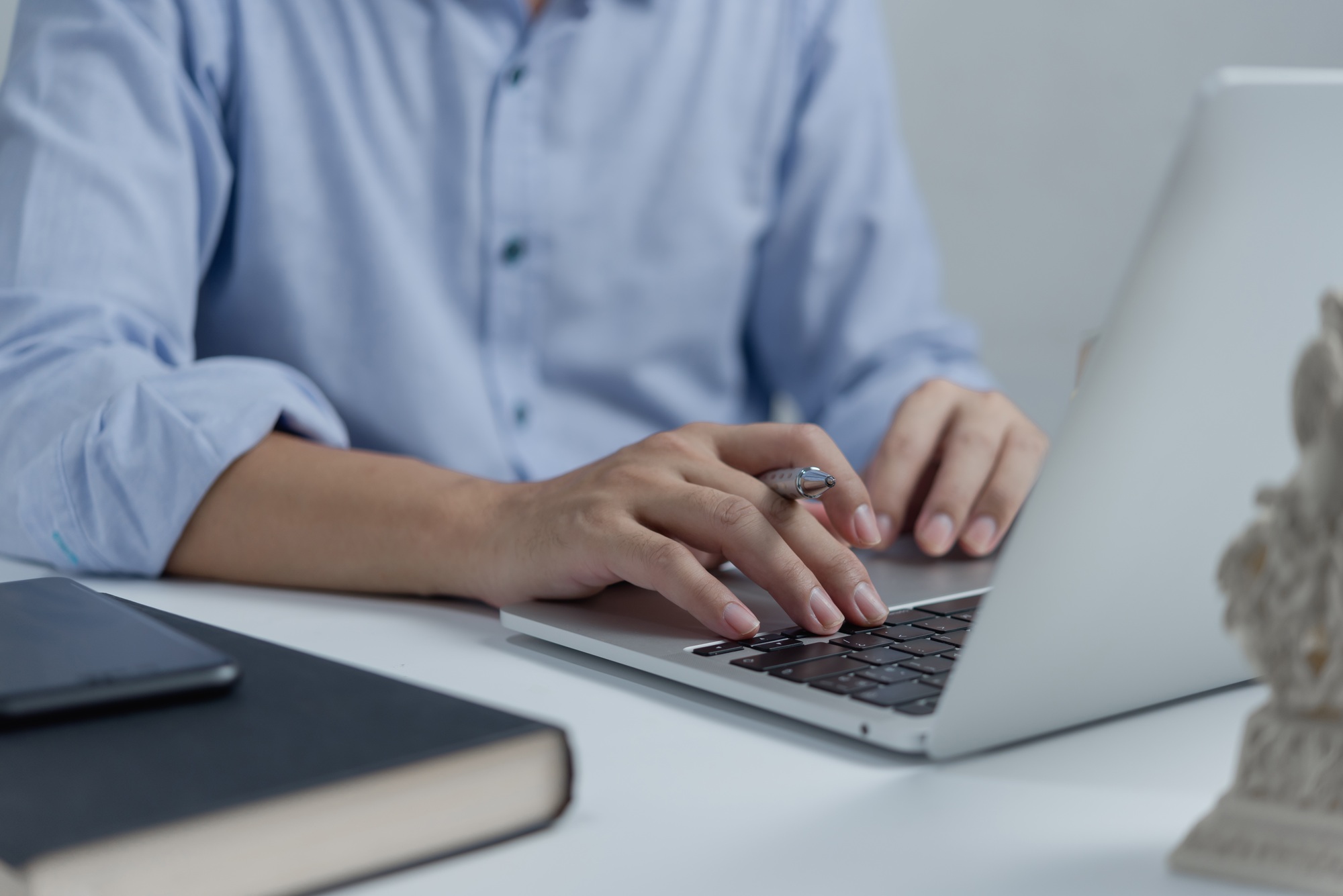 Businessperson hands working and typing on laptop keyboard on table.