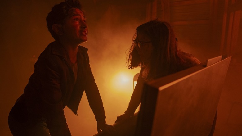 Arian S. Cartaya as Rich and Matilda Lawler as Marge trapped in a fiery room in It: Welcome to Derry