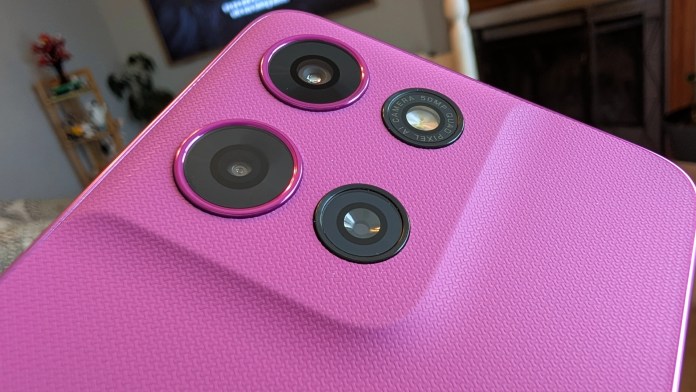 Close-up view of the back of a pink smartphone featuring three camera lenses.